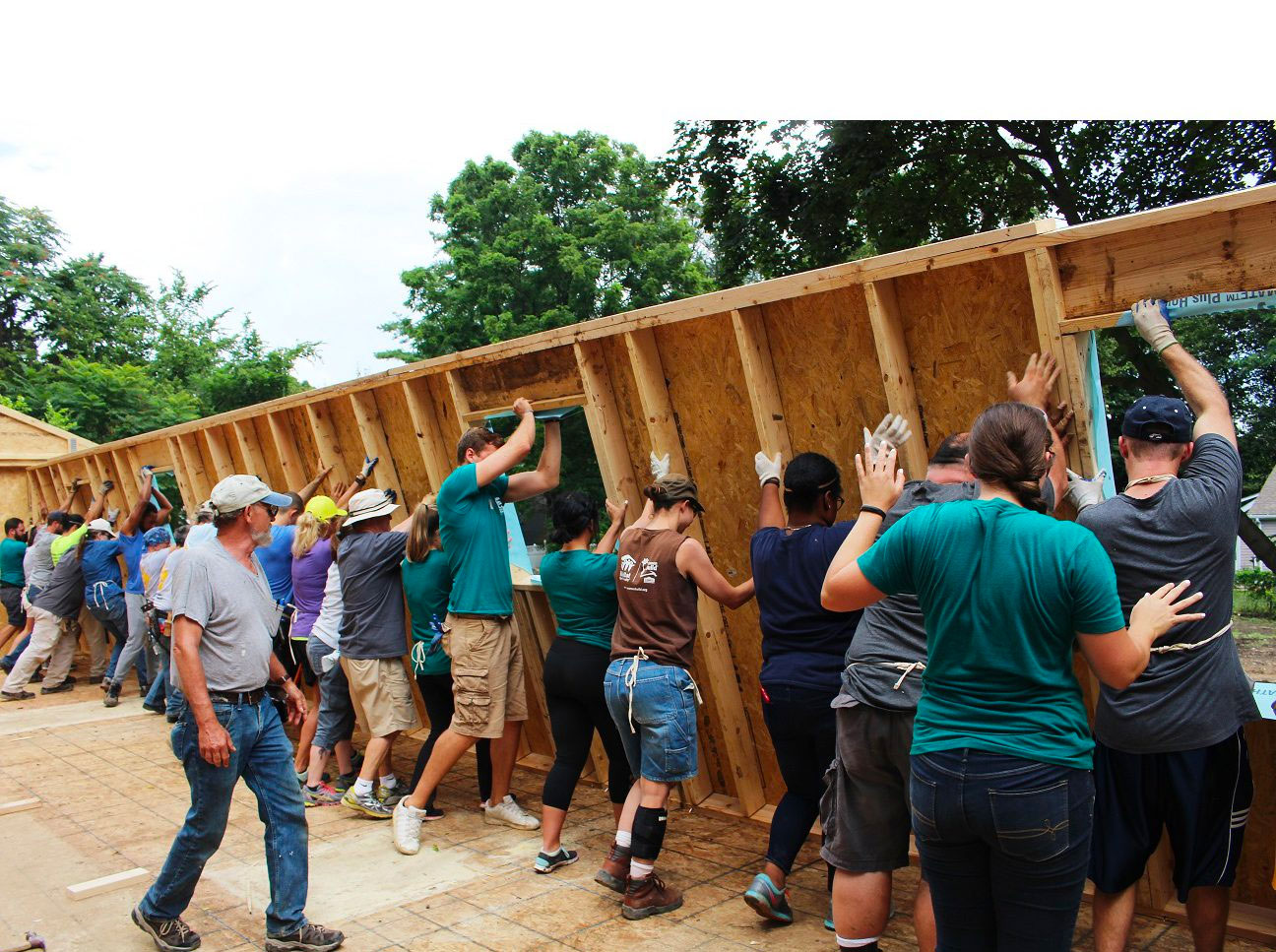Habitat Team raising a side wall of a house